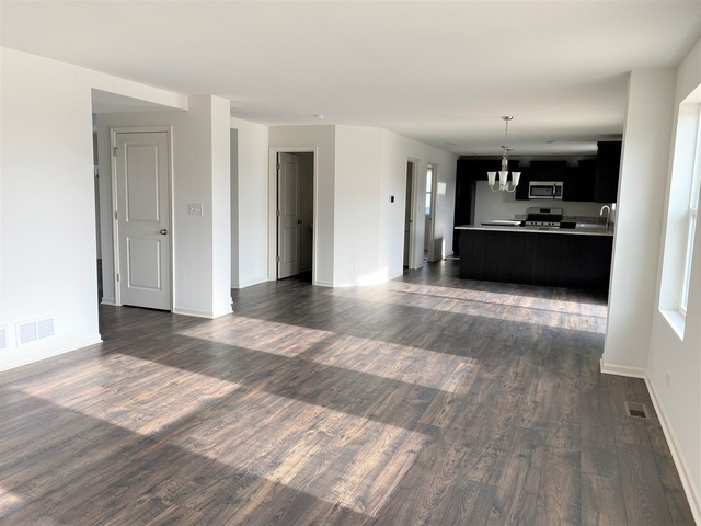 2019 Stapleton Road New Lenox, IL 60451 - Photo 7 of 17 a view of a kitchen with a sink dishwasher stove and cabinets with wooden floor