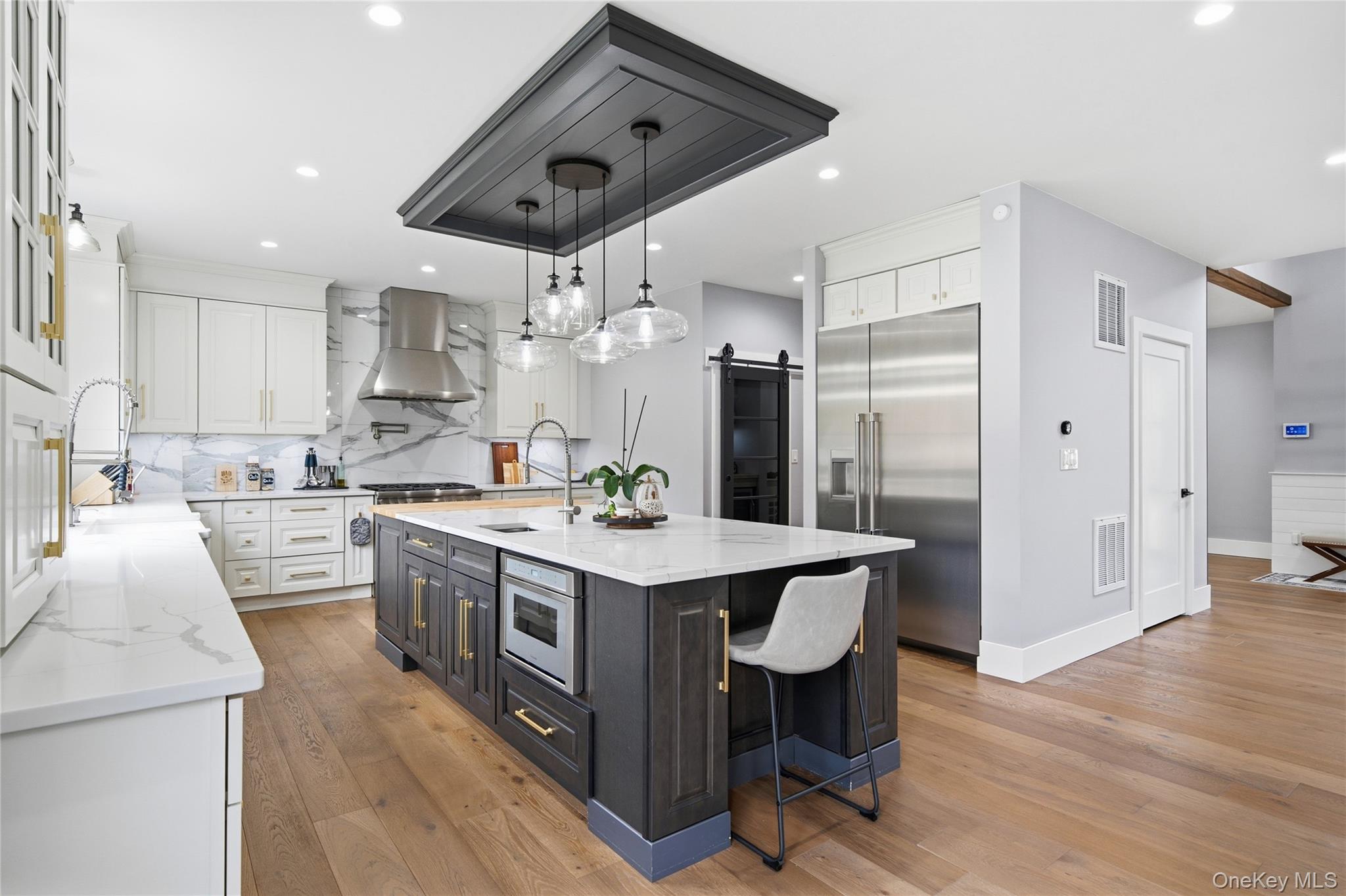 18 Timber Point Road East Islip, NY 11730 - Photo 5 of 34 a large kitchen with kitchen island a sink a stove a refrigerator and a dining table with wooden floor