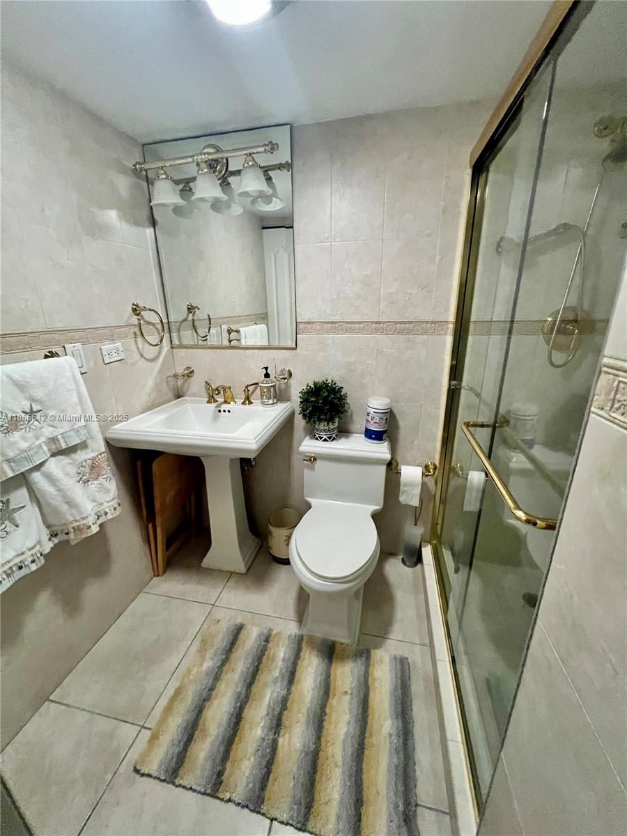 7135 Collins Avenue, Unit 1523 Miami Beach, FL 33141 - Photo 20 of 55 a bathroom with a sink a toilet a mirror and shower