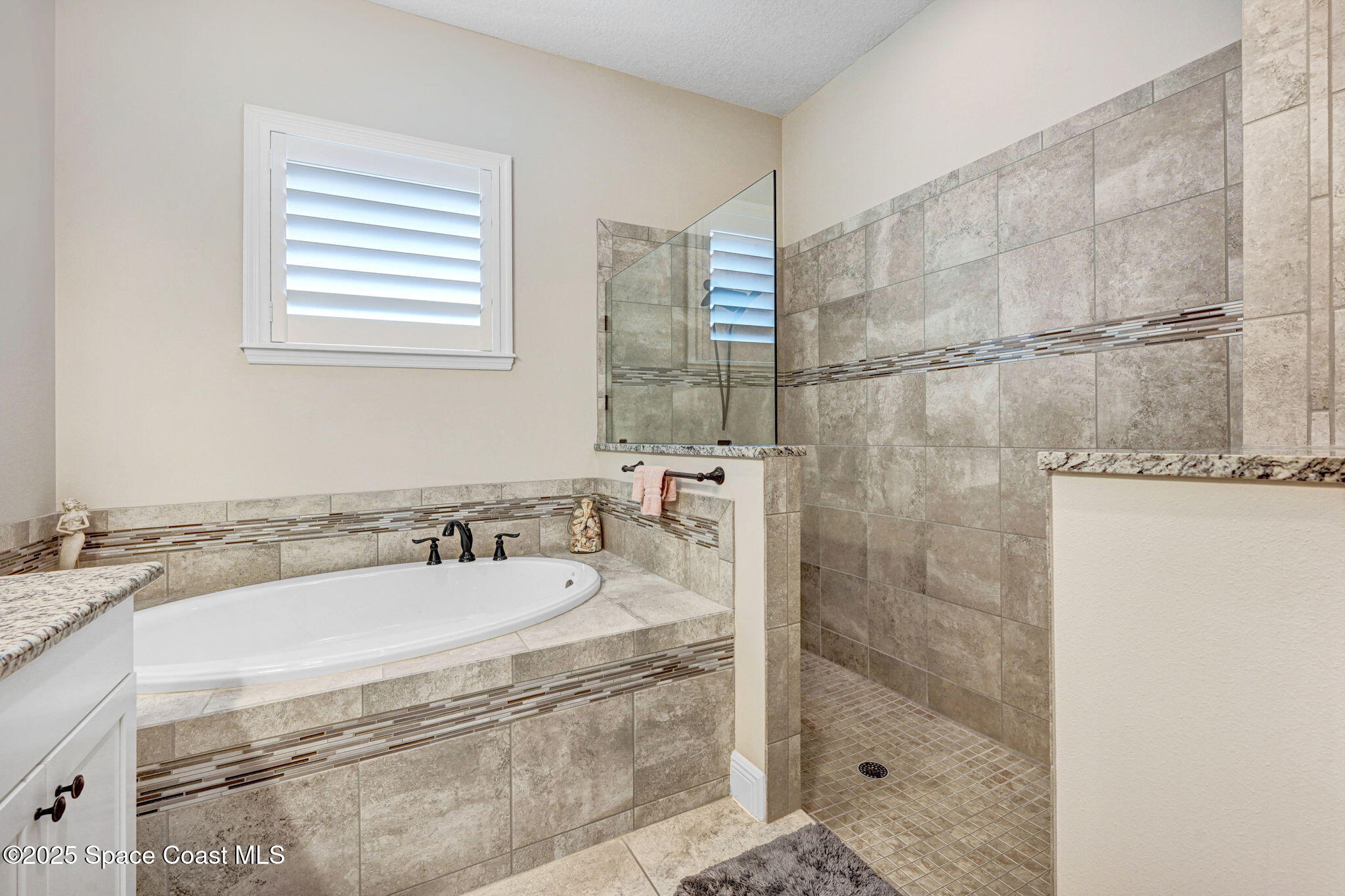 7072 Mercado Lane Melbourne, FL 32940 - Photo 13 of 32 a bathroom with a granite countertop sink a mirror and shower