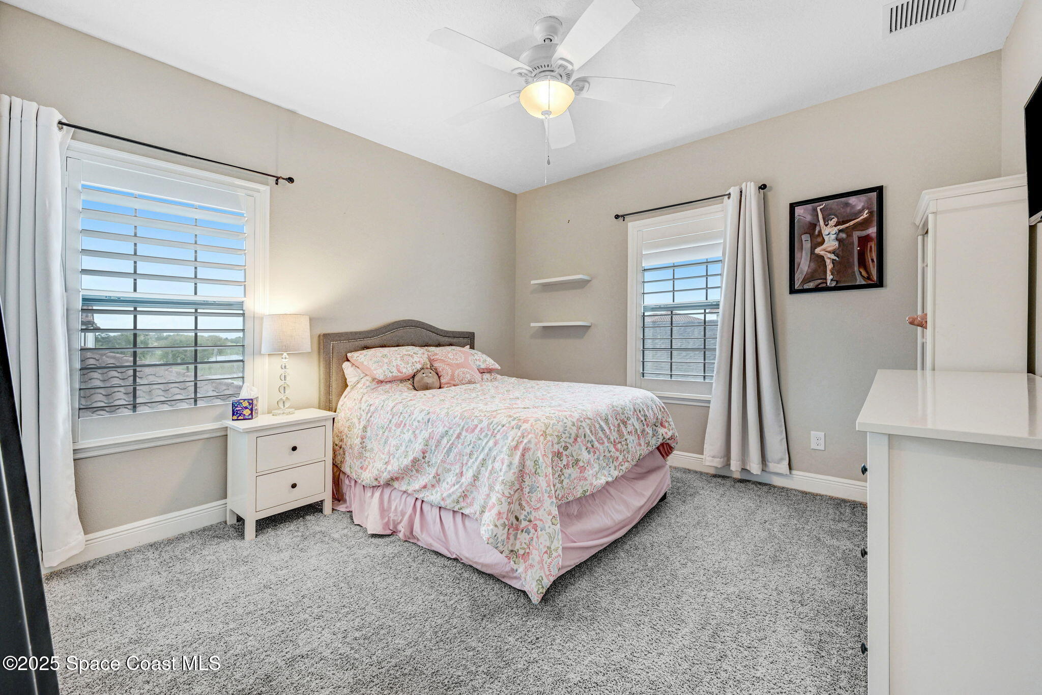 7072 Mercado Lane Melbourne, FL 32940 - Photo 21 of 32 a spacious bedroom with a bed and a chandelier
