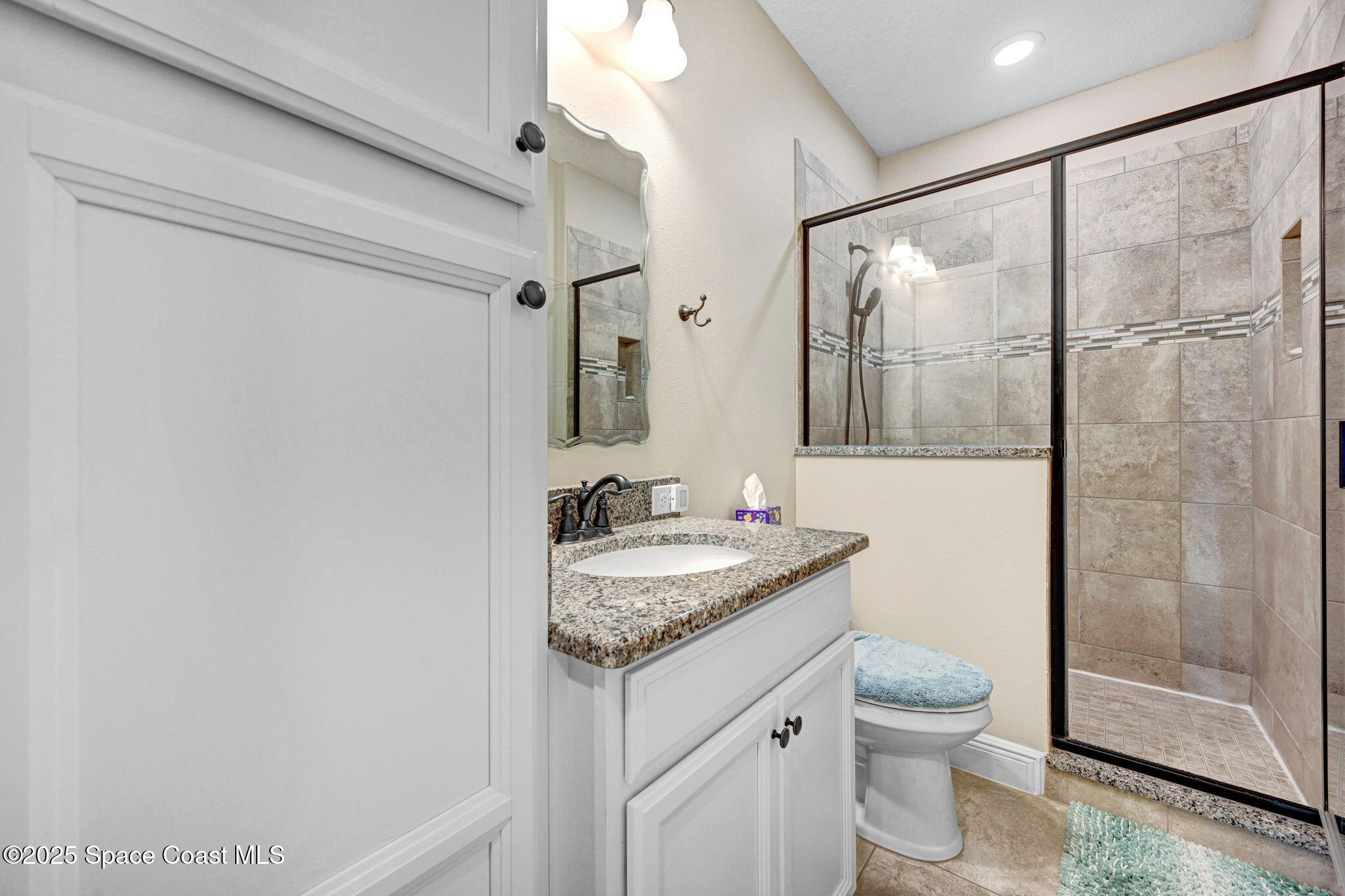 7072 Mercado Lane Melbourne, FL 32940 - Photo 22 of 32 a bathroom with a granite countertop sink toilet and shower
