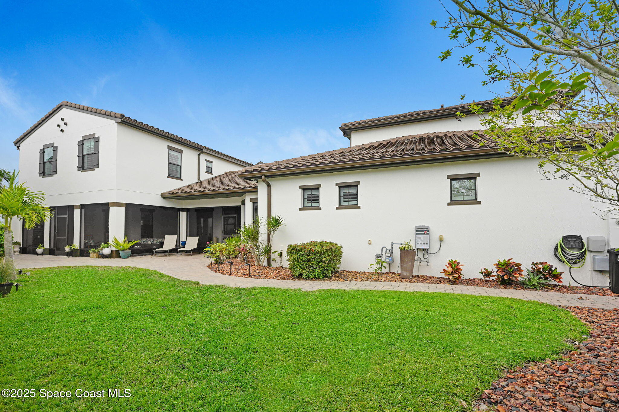7072 Mercado Lane Melbourne, FL 32940 - Photo 27 of 32 a front view of a house with a garden and chairs