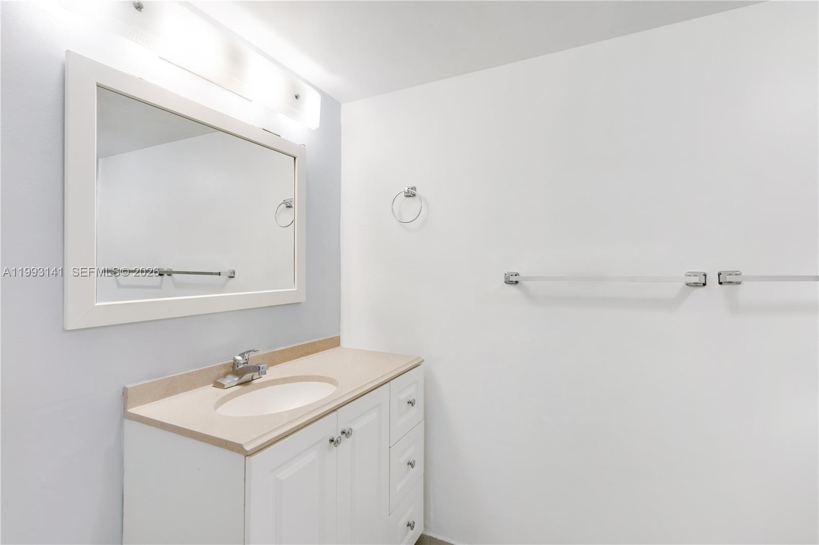 9423 Southwest 76th Street, Unit W21 Miami, FL 33173 - Photo 4 of 13 a bathroom with a sink a mirror and shower