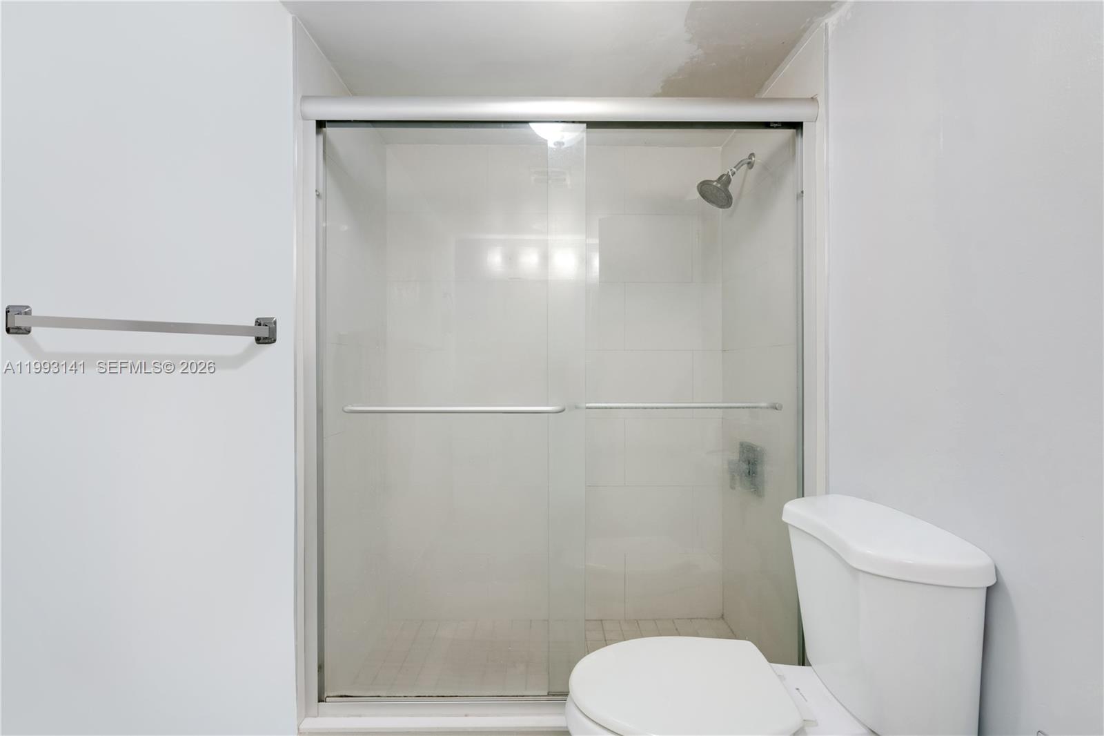 9423 Southwest 76th Street, Unit W21 Miami, FL 33173 - Photo 5 of 13 a white toilet sitting next to a shower