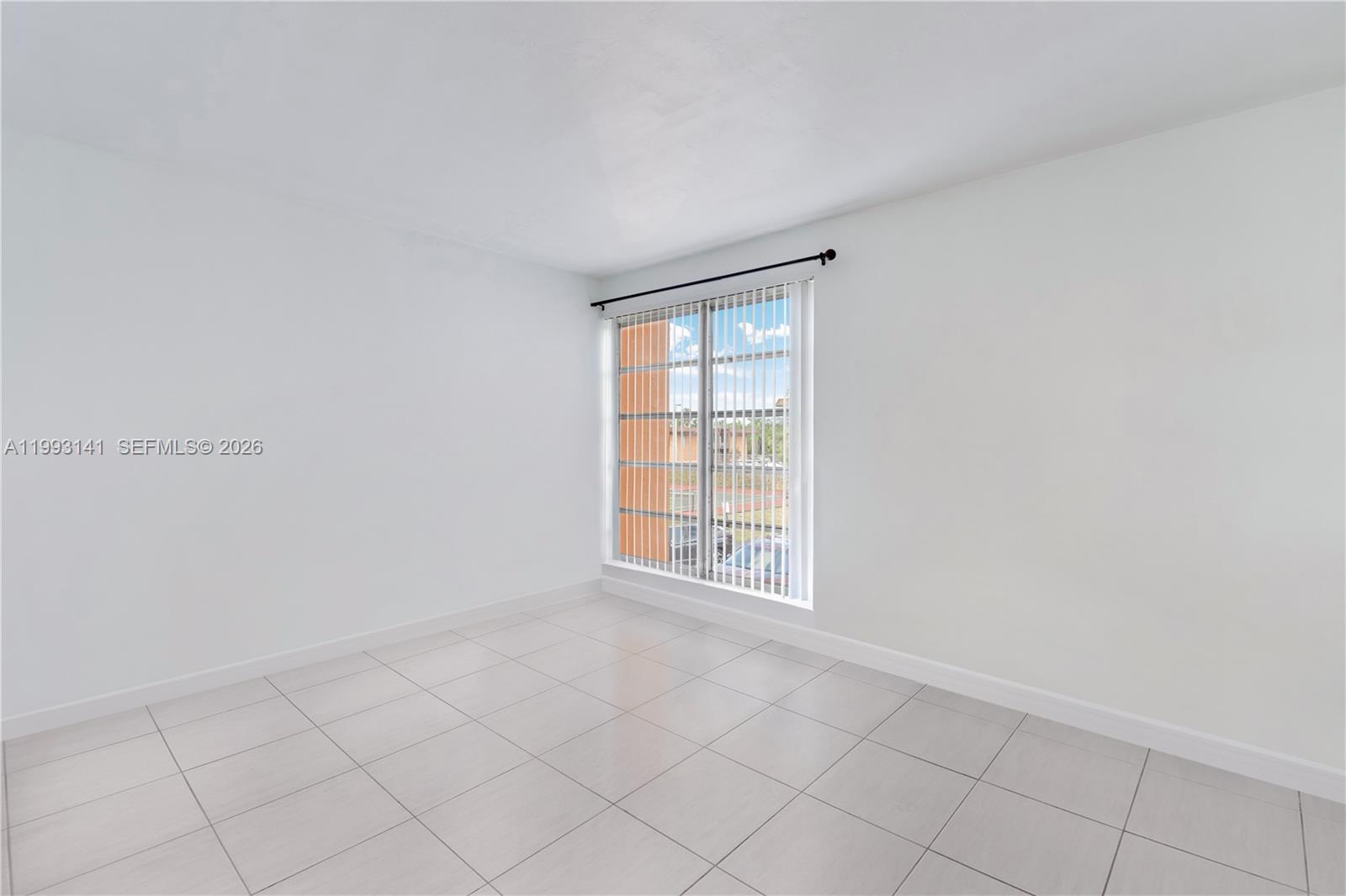 9423 Southwest 76th Street, Unit W21 Miami, FL 33173 - Photo 8 of 13 a view of an empty room with a window
