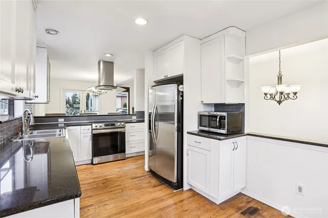 a kitchen with granite countertop a refrigerator stove and oven