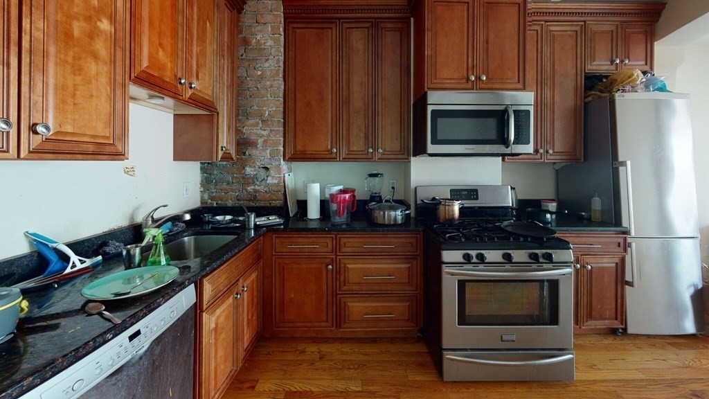a kitchen with stainless steel appliances a stove a microwave and wooden cabinets