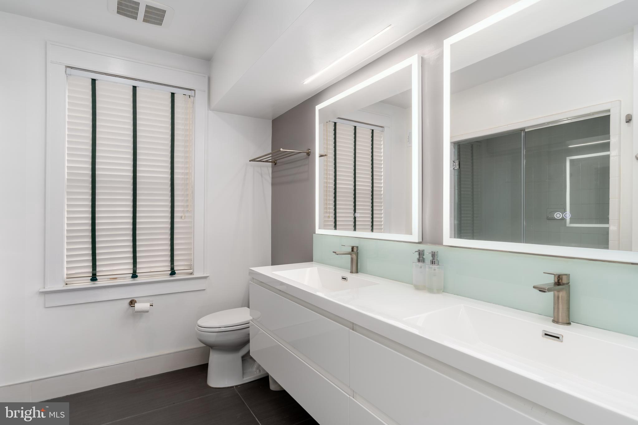 3415 Fulton Street Northwest Washington, DC 20007 - Photo 32 of 68 a bathroom with a double vanity sink toilet mirror and window