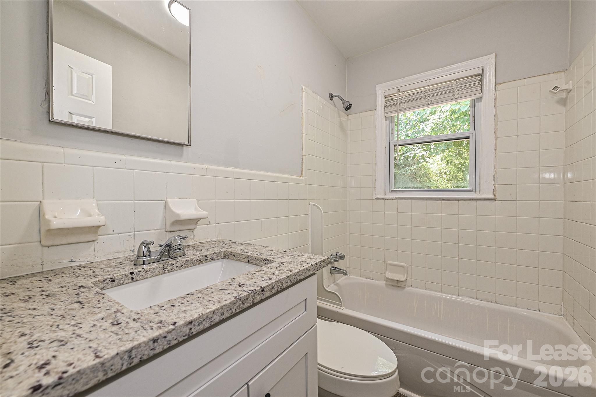 3429 Tappan Place, Unit 2 Charlotte, NC 28205 - Photo 12 of 16 a bathroom with a granite countertop sink a toilet and bathtub
