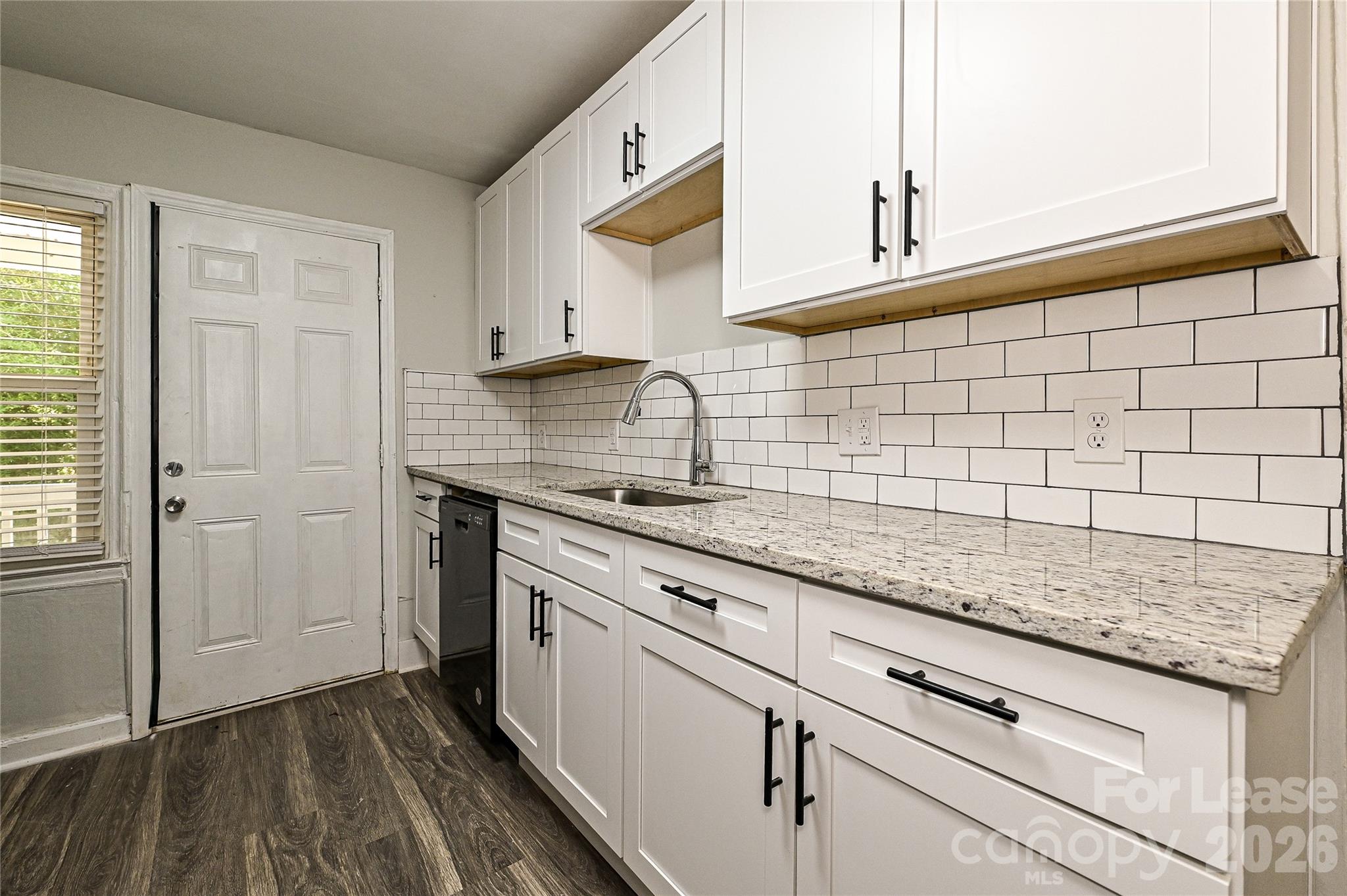 3429 Tappan Place, Unit 2 Charlotte, NC 28205 - Photo 8 of 16 a kitchen with granite countertop white cabinets and sink