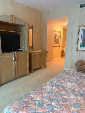 a bedroom with a bed and flat screen tv
