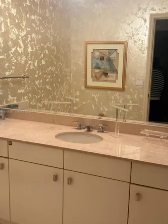 a bathroom with a granite countertop sink a mirror and vanity