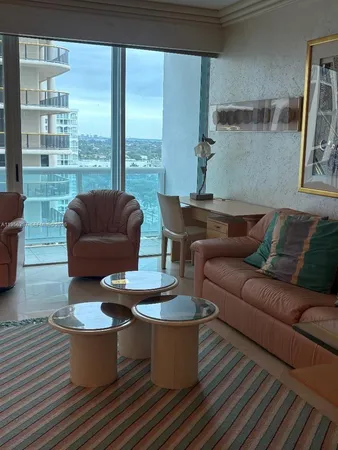 a living room with furniture and a floor to ceiling window