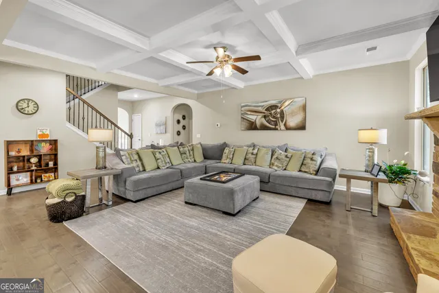 a view of a dining room and livingroom with furniture wooden floor a chandelier
