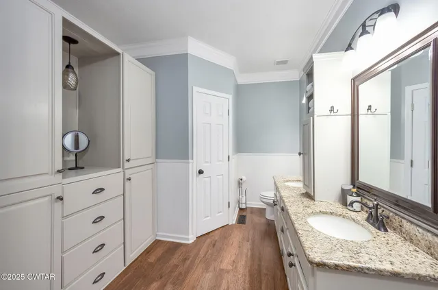a en suite bathroom with a granite countertop sink and a mirror