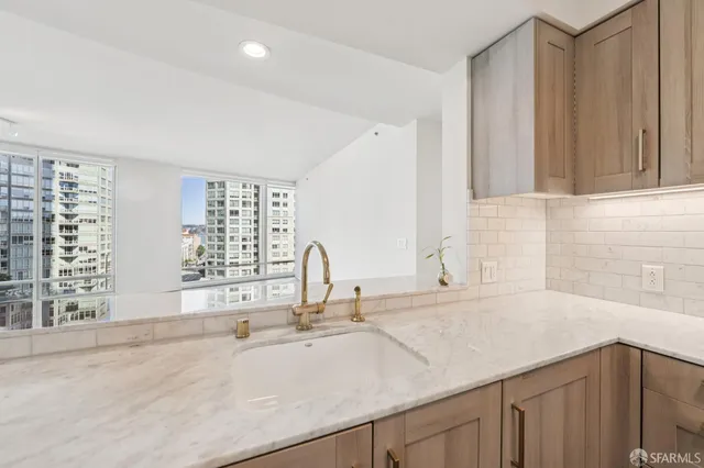 a kitchen with white cabinets and sink