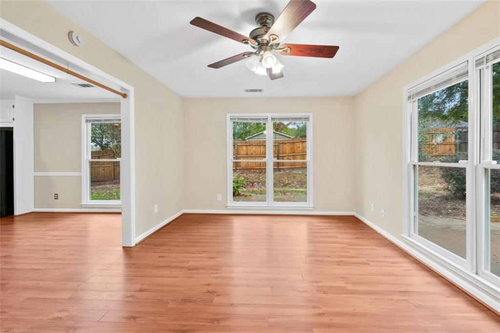 2985 Ashton Pointe Circle Dacula, GA 30019 - Photo 13 of 47 an empty room with wooden floor chandelier and windows