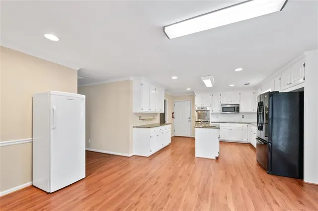 a kitchen with stainless steel appliances wooden floors and refrigerator
