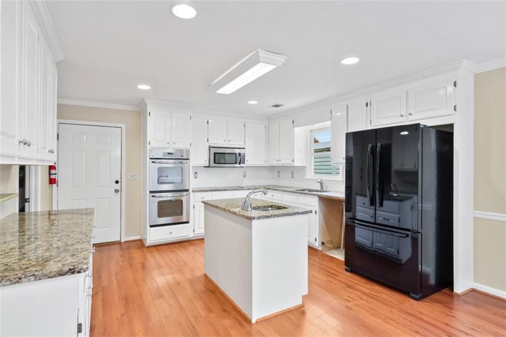 2985 Ashton Pointe Circle Dacula, GA 30019 - Photo 16 of 47 a kitchen with stainless steel appliances granite countertop a refrigerator and a stove top oven