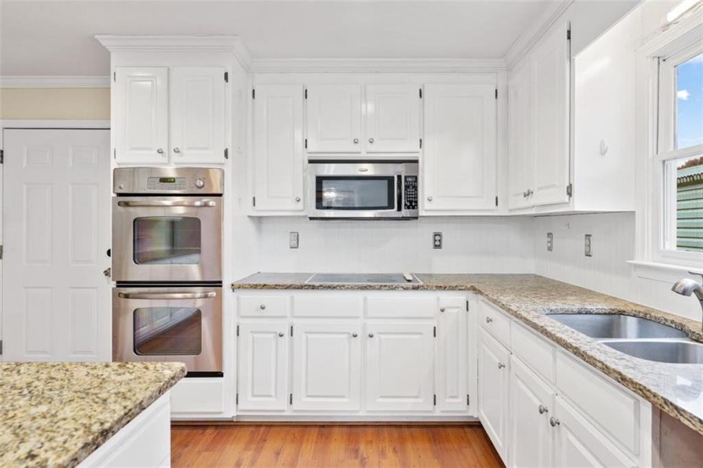 2985 Ashton Pointe Circle Dacula, GA 30019 - Photo 17 of 47 a kitchen with granite countertop white cabinets and stainless steel appliances
