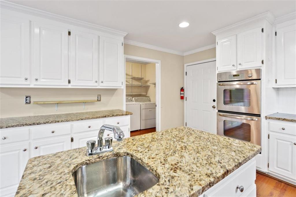 2985 Ashton Pointe Circle Dacula, GA 30019 - Photo 18 of 47 a kitchen with stainless steel appliances granite countertop a sink stove and refrigerator