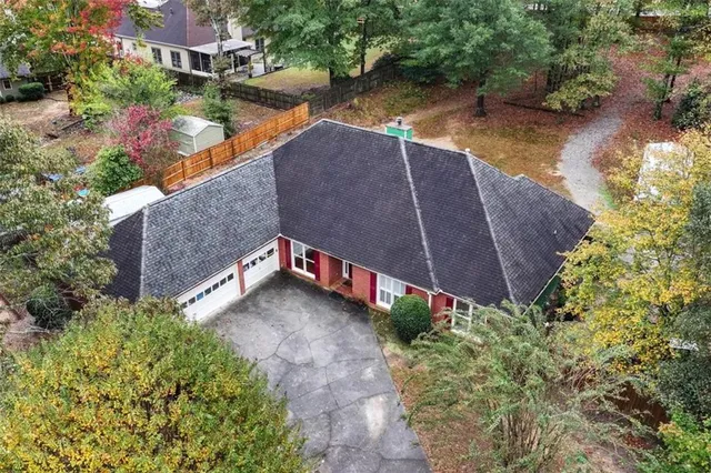 an aerial view of a house with a yard and a large tree