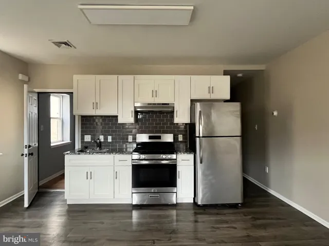 a kitchen with a refrigerator and a stove top oven