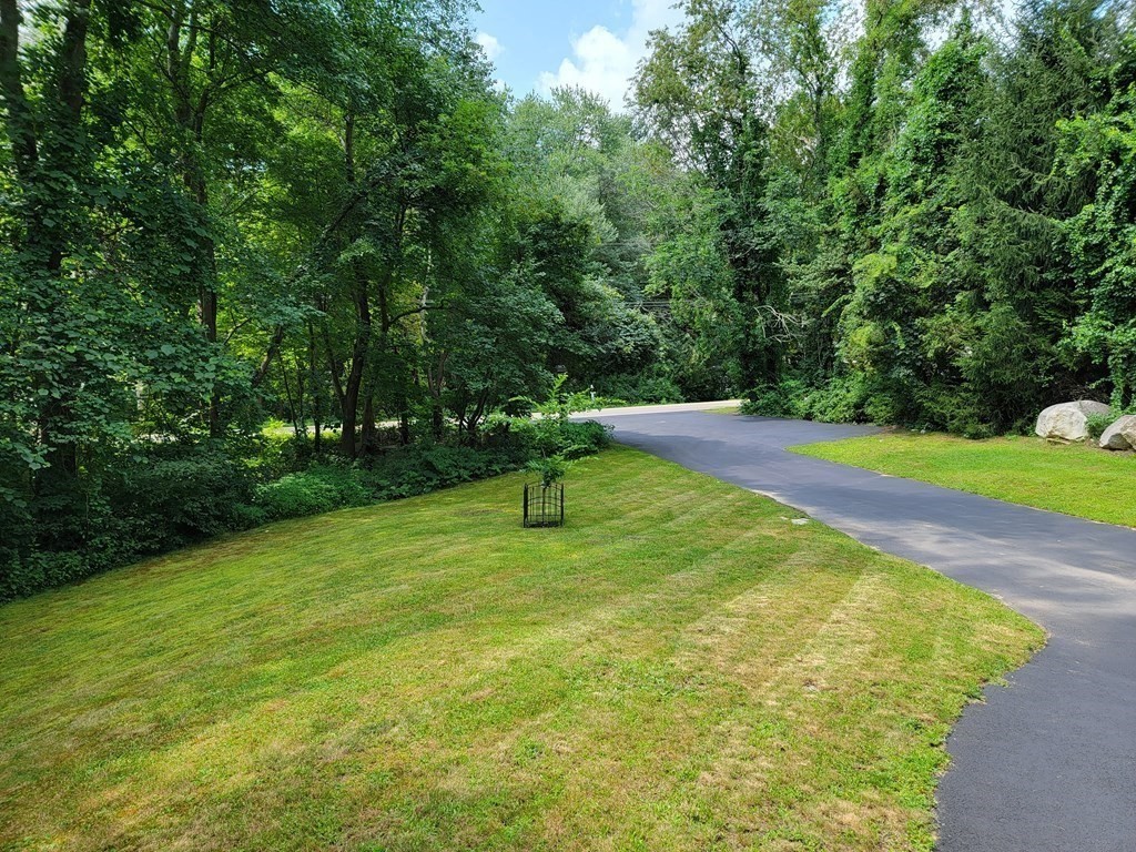 94 West Street Medway, MA 02053 - Photo 30 of 41 a swimming pool with lots of green space and trees in the background