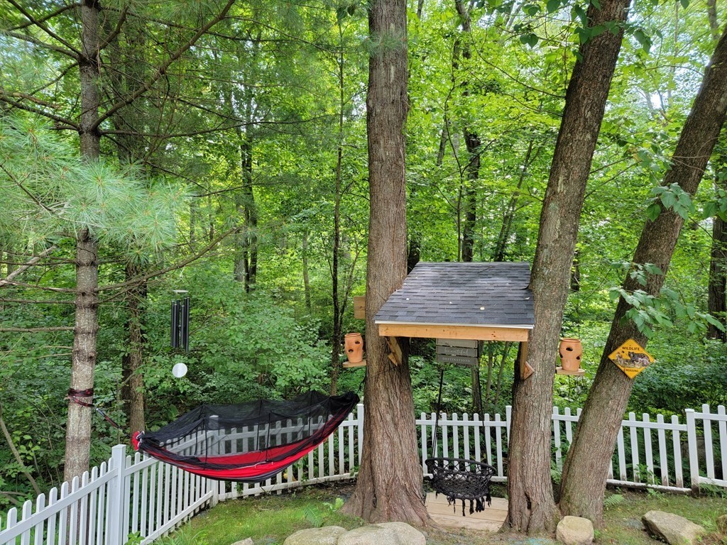 94 West Street Medway, MA 02053 - Photo 31 of 41 a view of a wooden house with a small yard and potted plants