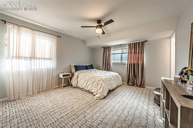 a bedroom with a bed and large windows