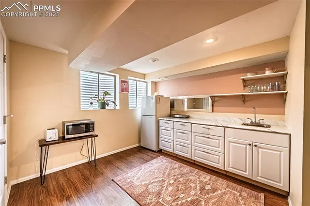 a kitchen with granite countertop a stove a sink and a microwave