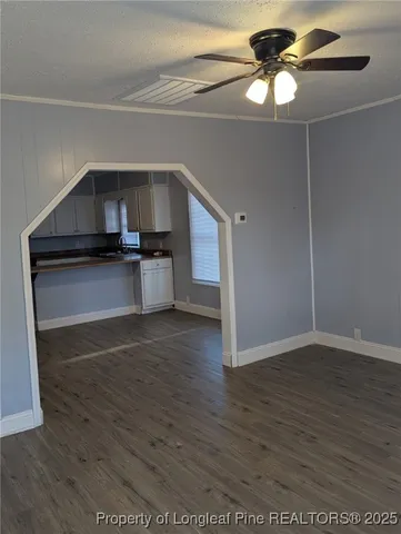 a kitchen with stainless steel appliances a wooden floor and a chandelier