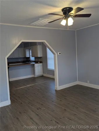 a kitchen with stainless steel appliances a wooden floor and a chandelier