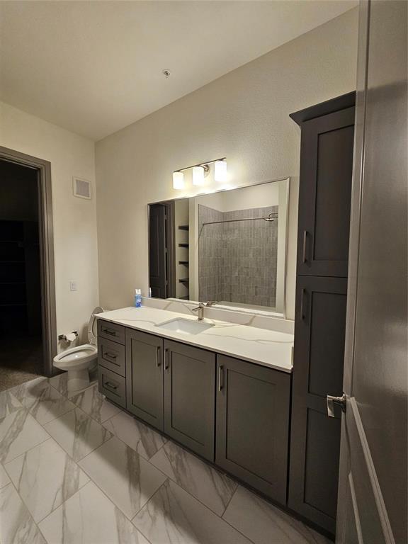 2700 Old Denton Road, Unit 3325 Carrollton, TX 75007 - Photo 4 of 6 Bathroom vanity featuring dual sinks, white countertops, and dark gray cabinetry