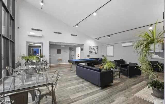 a living room with furniture potted plant and kitchen view