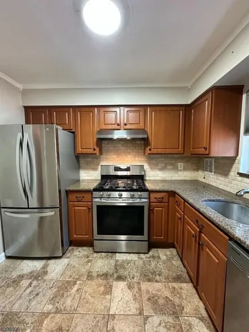a kitchen with granite countertop a refrigerator and a stove