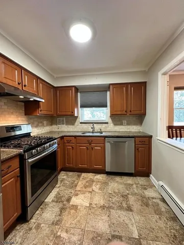 a large kitchen with stainless steel appliances granite countertop a stove a sink dishwasher a microwave oven and a refrigerator