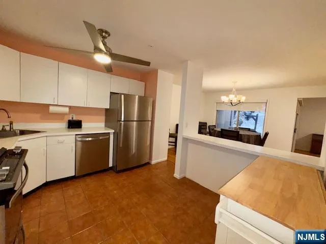 a kitchen with a refrigerator sink and cabinets