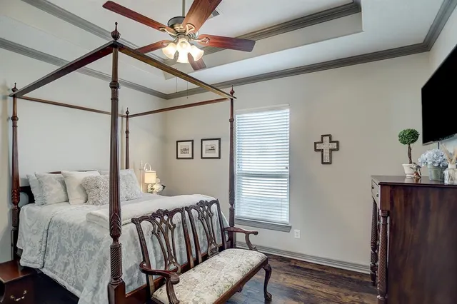 a bedroom with a bed window and a flat screen tv