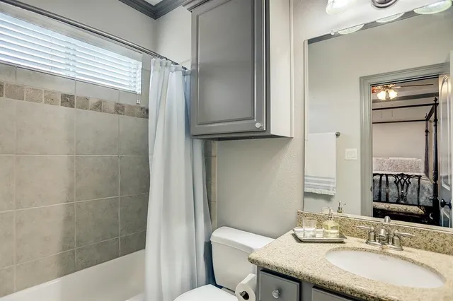 a bathroom with a granite countertop sink toilet and shower