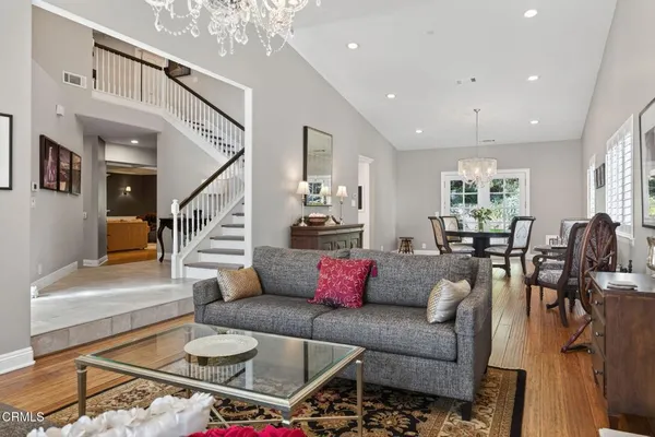 a dining room with furniture a chandelier and wooden floor