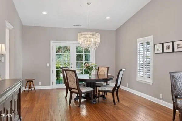 a view of a dining room with furniture a chandelier and wooden floor