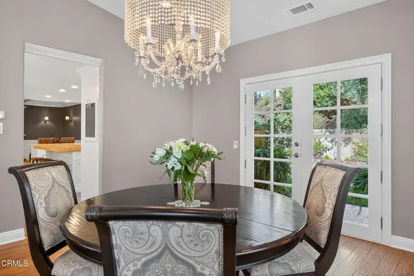 a kitchen with stainless steel appliances kitchen island granite countertop a table chairs sink and cabinets