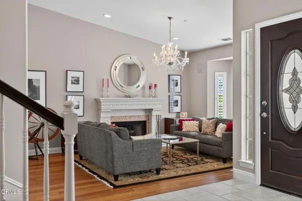 a living room with furniture a chandelier and a fireplace