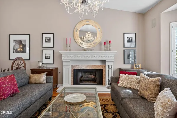 a living room with furniture a chandelier and a fireplace