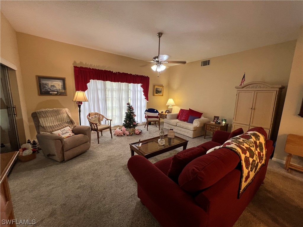 3 Regency Court Lehigh Acres, FL 33936 - Photo 14 of 27 a living room with furniture and a chandelier
