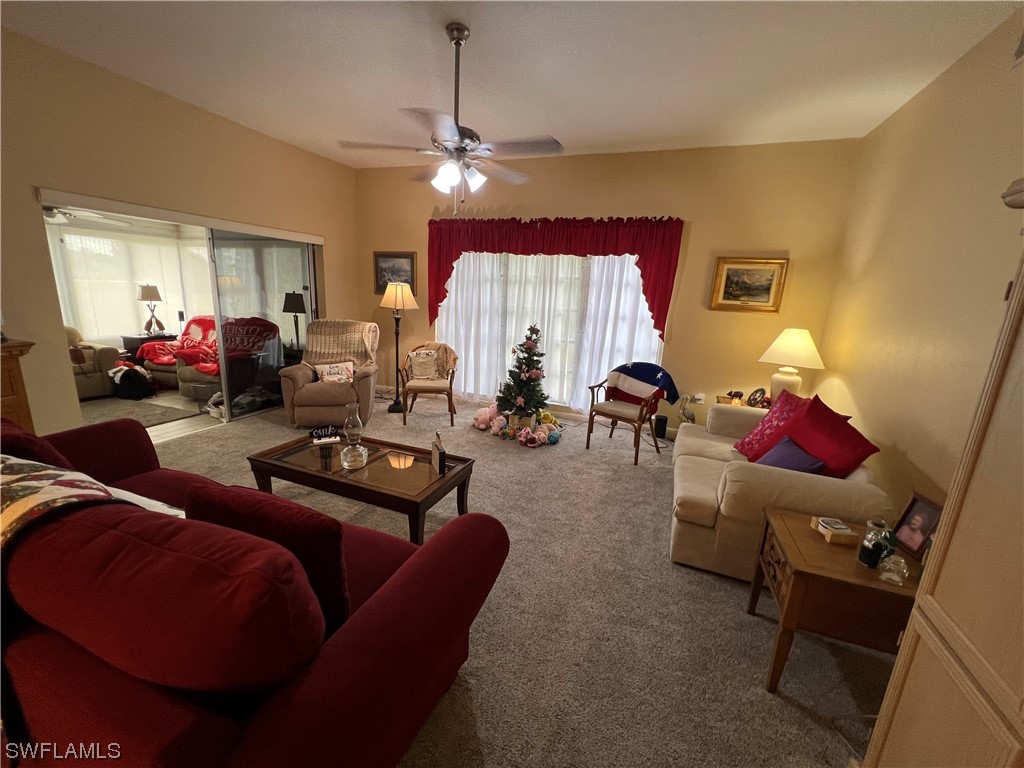 3 Regency Court Lehigh Acres, FL 33936 - Photo 15 of 27 a living room with furniture and a chandelier