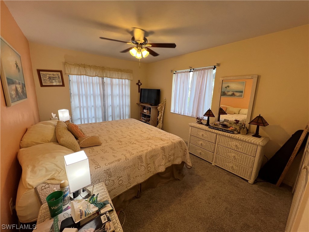 3 Regency Court Lehigh Acres, FL 33936 - Photo 19 of 27 a bed room with a bed and a chandelier