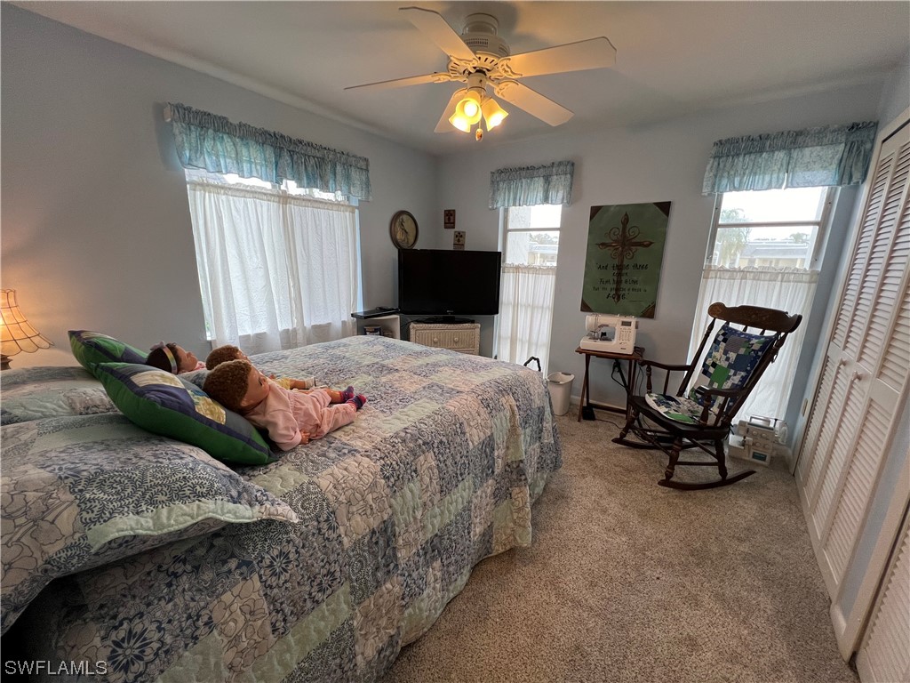 3 Regency Court Lehigh Acres, FL 33936 - Photo 21 of 27 a bedroom with a bed and a chandelier